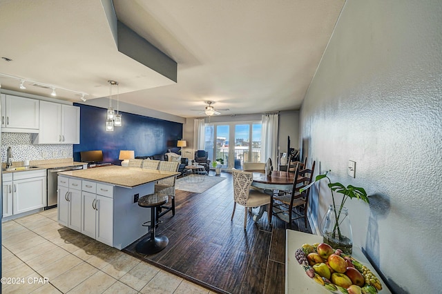 kitchen with light hardwood / wood-style floors, white cabinetry, hanging light fixtures, and a kitchen island