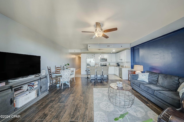 living room featuring ceiling fan, dark wood-type flooring, and sink