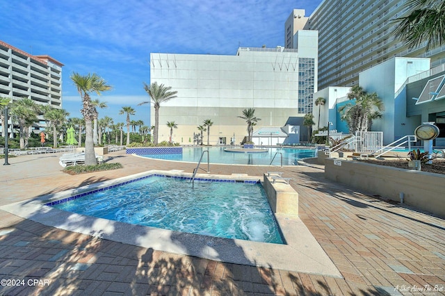 view of swimming pool with a patio and a hot tub