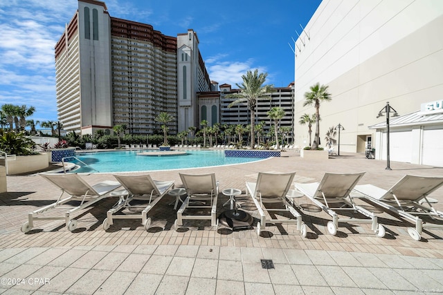 view of swimming pool featuring pool water feature and a patio area