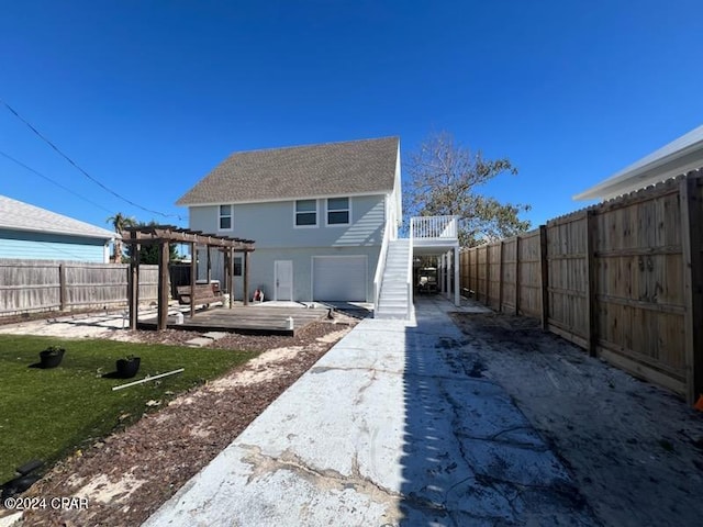 back of property with a lawn, a pergola, and a wooden deck