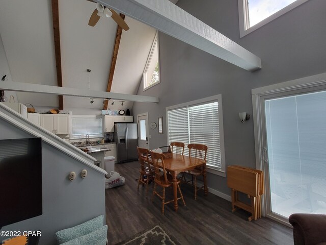 dining space with dark hardwood / wood-style flooring, ceiling fan, sink, beam ceiling, and high vaulted ceiling