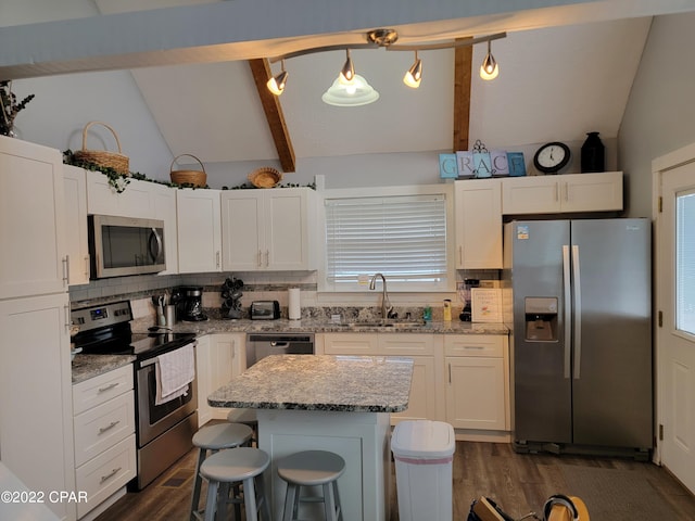 kitchen featuring white cabinetry, sink, hanging light fixtures, stainless steel appliances, and lofted ceiling with beams