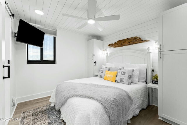 bedroom with ceiling fan, dark hardwood / wood-style flooring, and wood ceiling