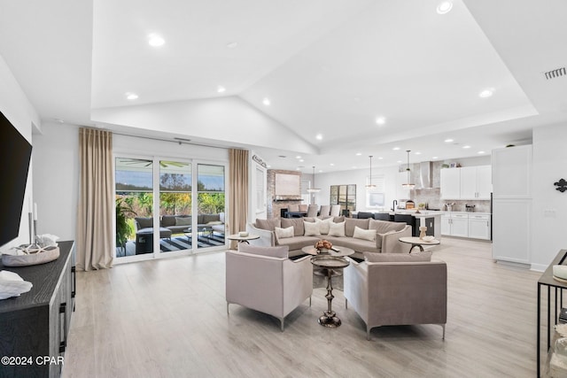 living room featuring light wood-type flooring and high vaulted ceiling