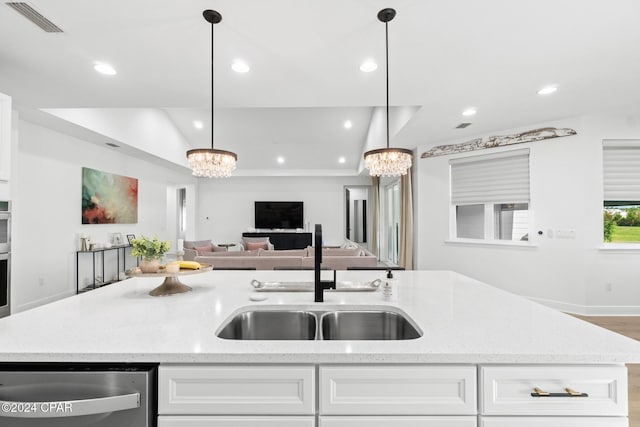 kitchen with white cabinets, pendant lighting, sink, and an inviting chandelier