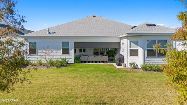 back of property with outdoor lounge area and a lawn