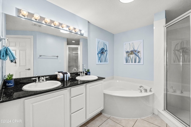 bathroom with tile patterned flooring, vanity, shower with separate bathtub, and a textured ceiling