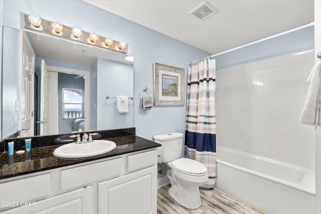 full bathroom featuring vanity, hardwood / wood-style flooring, toilet, and shower / bath combo with shower curtain