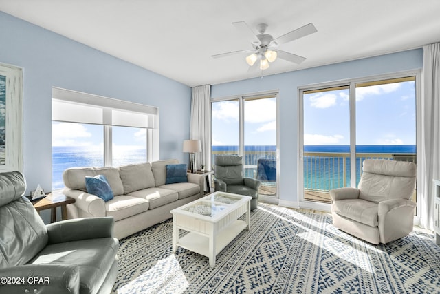 living room with a water view and ceiling fan