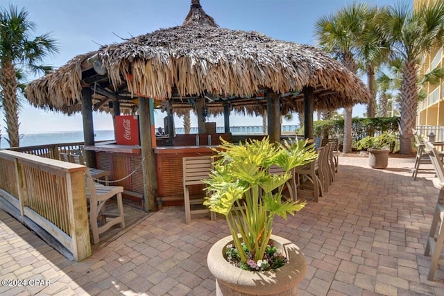 view of patio / terrace featuring a gazebo, a water view, and exterior bar