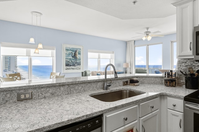 kitchen with white cabinetry, sink, a water view, and pendant lighting