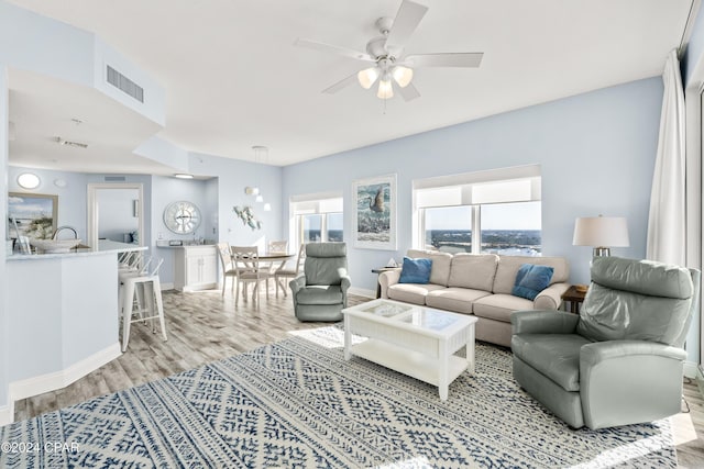 living room featuring ceiling fan and light wood-type flooring