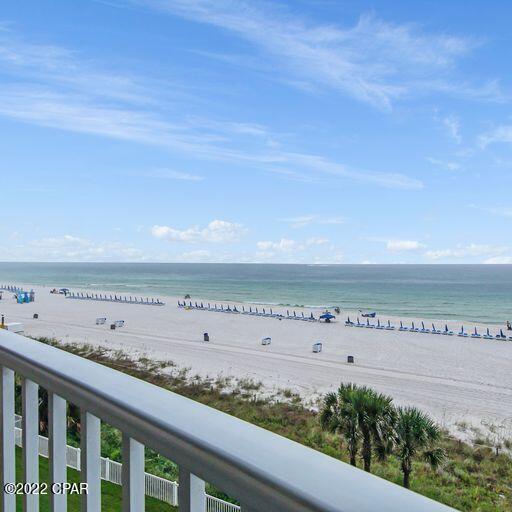 balcony featuring a water view and a beach view