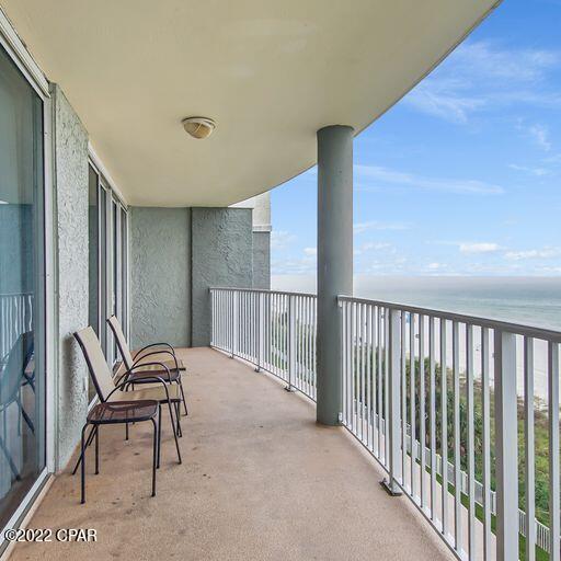 balcony with a water view and a view of the beach