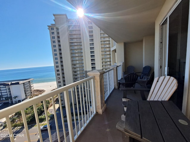 balcony featuring a water view and a beach view