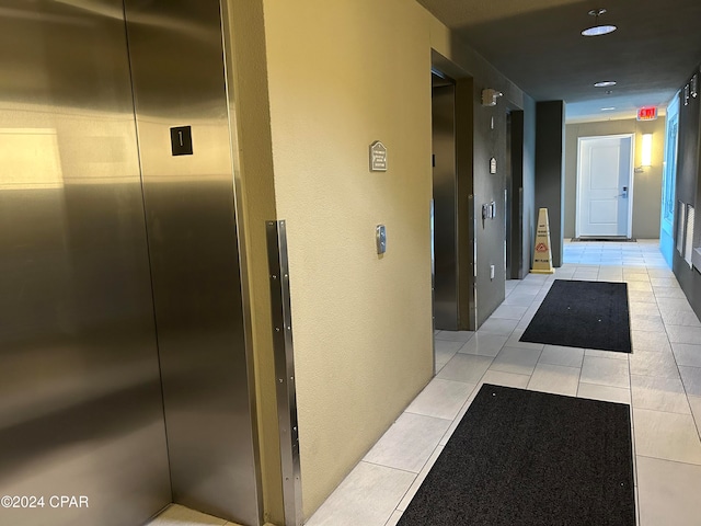 hallway with light tile patterned floors and elevator