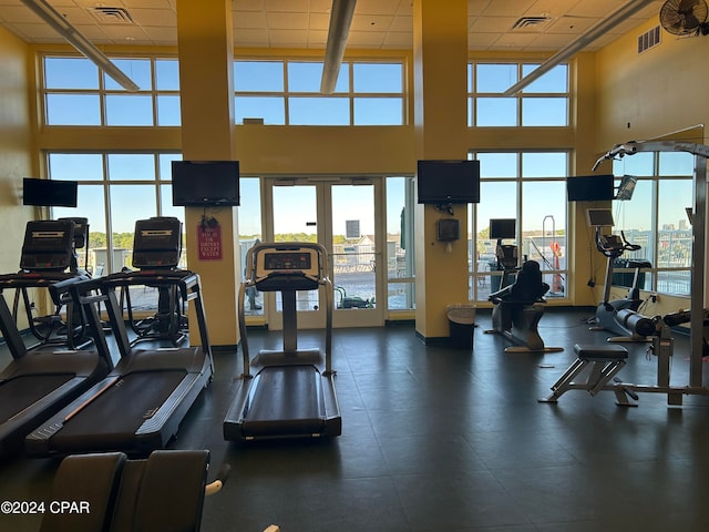 gym with a towering ceiling and a paneled ceiling