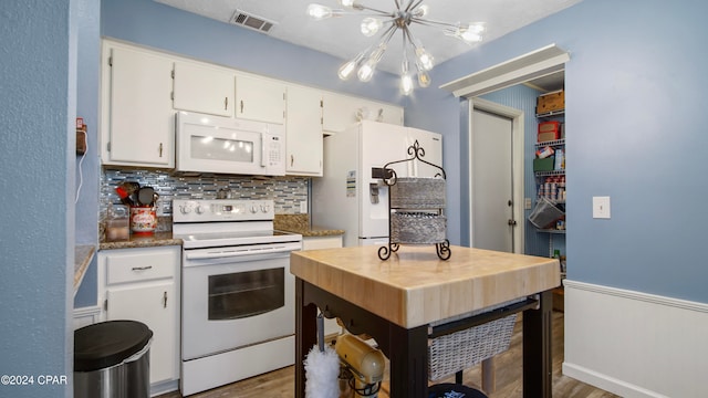 kitchen with an inviting chandelier, hardwood / wood-style floors, white appliances, decorative backsplash, and white cabinets