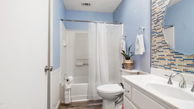 full bathroom with hardwood / wood-style floors, backsplash, shower / bath combination with curtain, toilet, and a textured ceiling