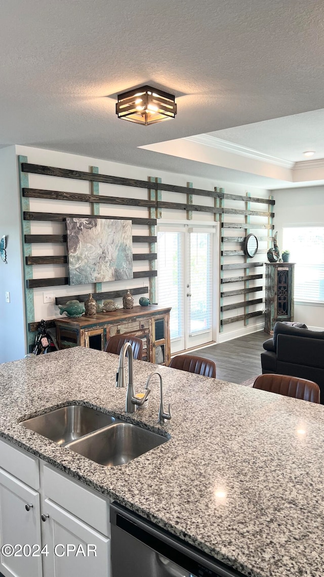 kitchen featuring light stone countertops, dark hardwood / wood-style flooring, a textured ceiling, sink, and white cabinetry