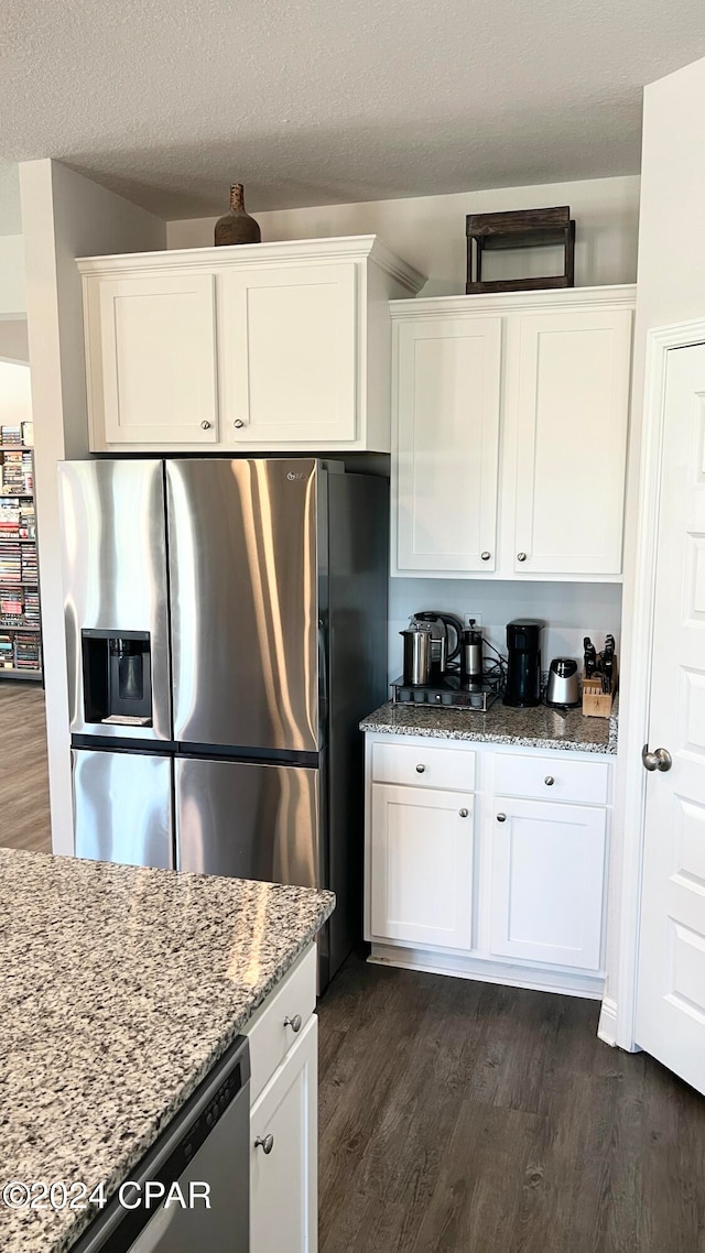 kitchen featuring appliances with stainless steel finishes, white cabinetry, and light stone counters