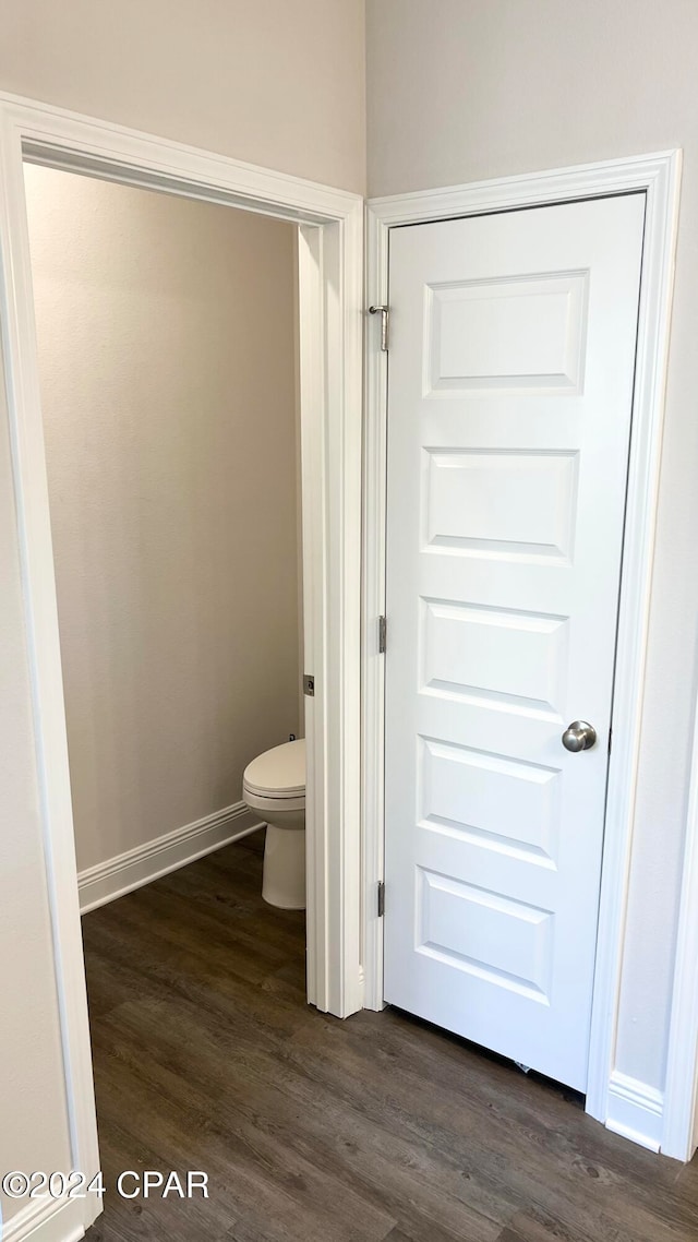 bathroom featuring wood-type flooring and toilet