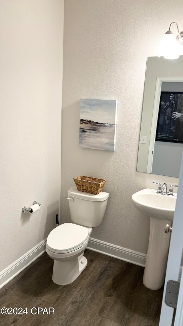 bathroom with hardwood / wood-style flooring and toilet