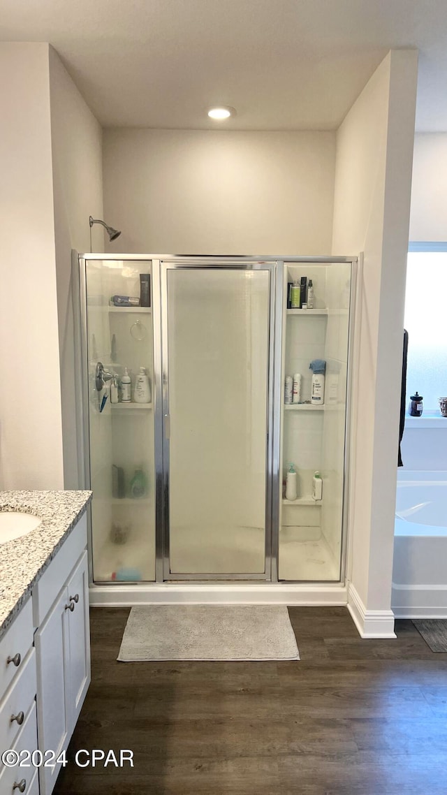 bathroom featuring vanity, independent shower and bath, and hardwood / wood-style flooring