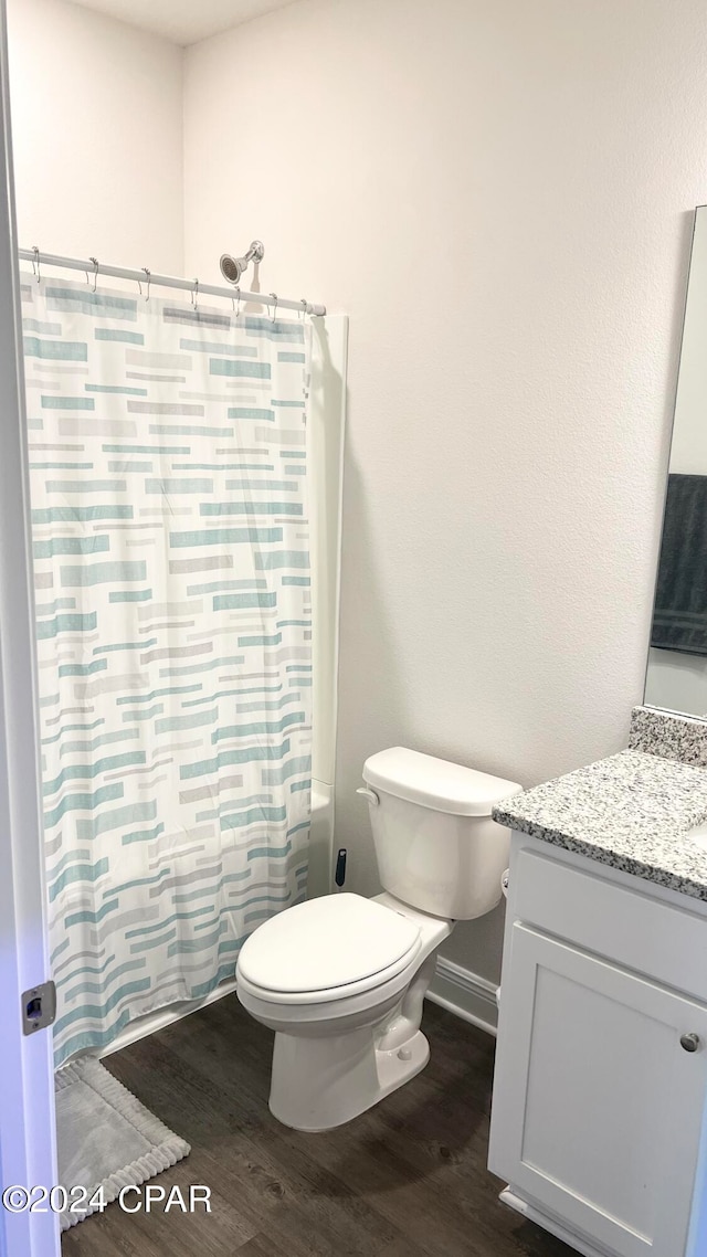 full bathroom featuring vanity, hardwood / wood-style flooring, toilet, and shower / bathtub combination with curtain