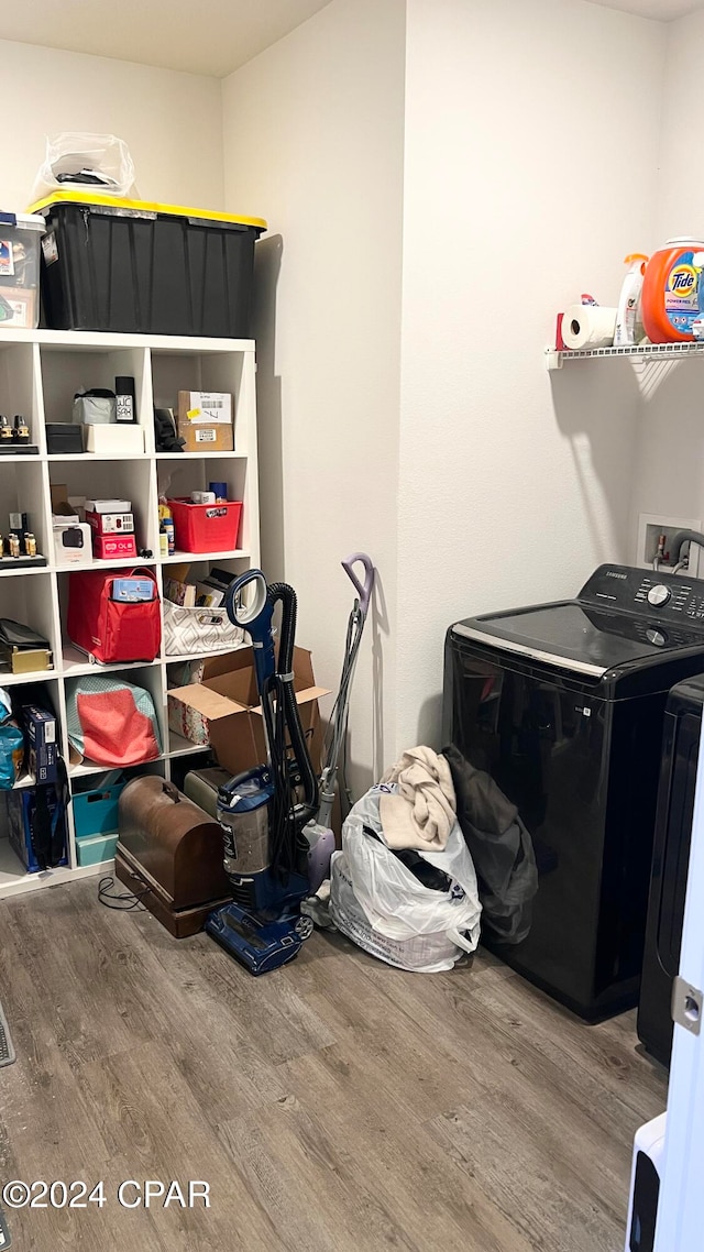 laundry room with hardwood / wood-style flooring and washer / dryer