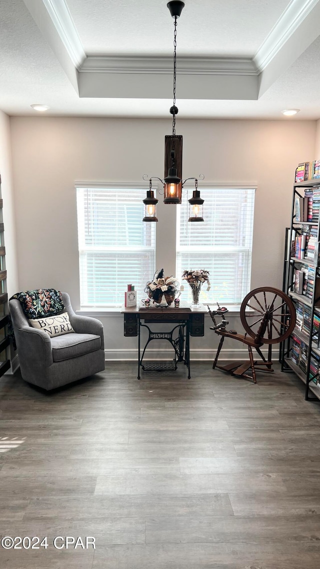 sitting room with a tray ceiling, crown molding, and hardwood / wood-style flooring