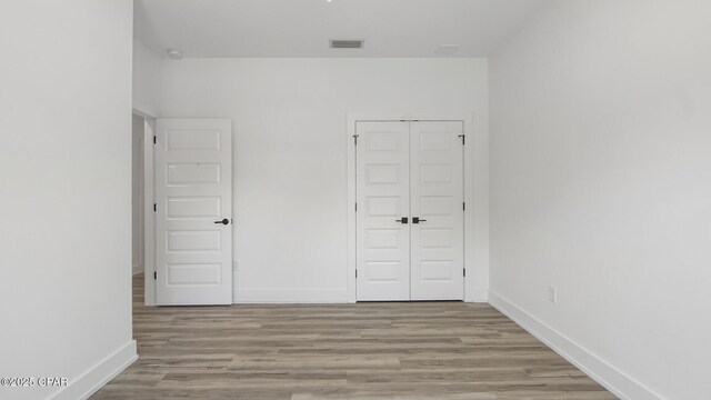 unfurnished bedroom featuring light wood-type flooring and a closet