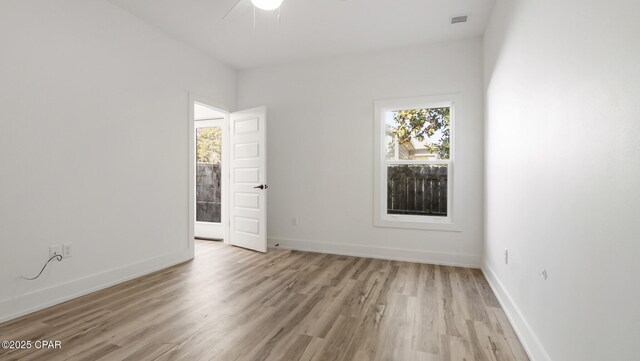 spare room with ceiling fan, a healthy amount of sunlight, and light wood-type flooring