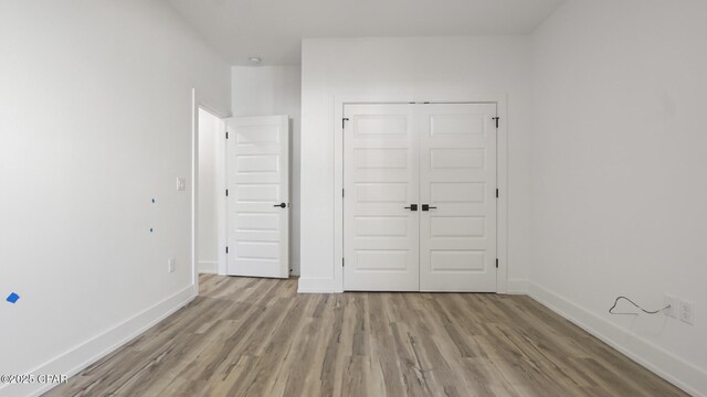 unfurnished bedroom with light hardwood / wood-style flooring and a closet