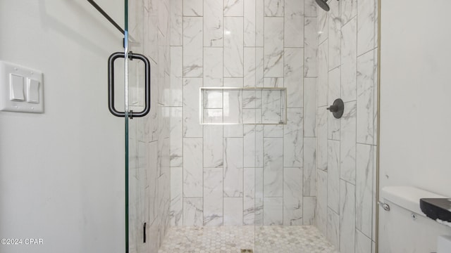 bathroom featuring an enclosed shower and toilet