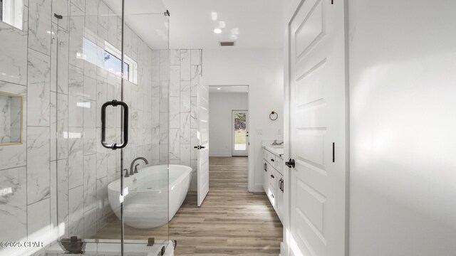 bathroom with hardwood / wood-style floors, vanity, shower with separate bathtub, and a healthy amount of sunlight