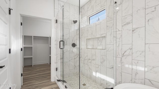 bathroom featuring plus walk in shower and hardwood / wood-style flooring