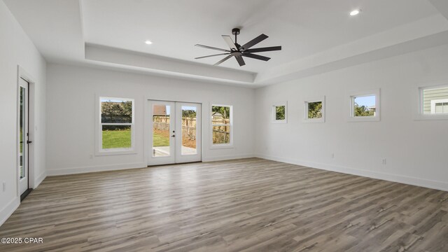 unfurnished room with a healthy amount of sunlight, wood-type flooring, and french doors