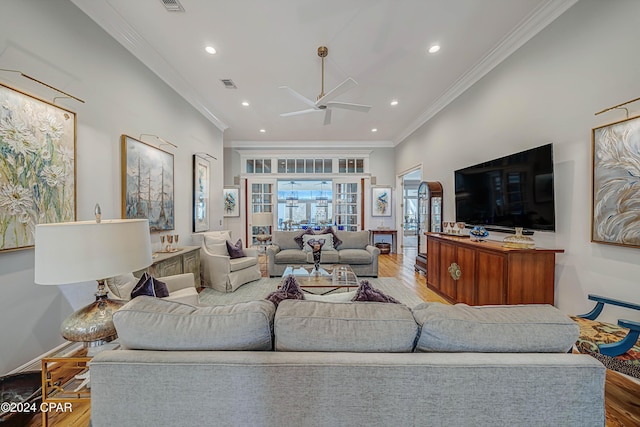 living room with hardwood / wood-style flooring, crown molding, and ceiling fan