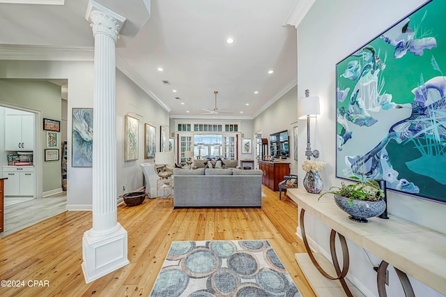 living room with ornate columns, crown molding, ceiling fan, and light hardwood / wood-style flooring