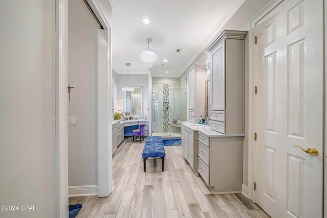 bathroom featuring wood-type flooring, walk in shower, a chandelier, crown molding, and vanity