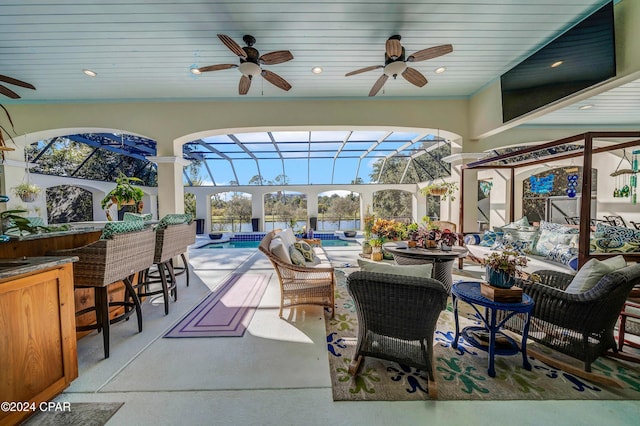 view of patio / terrace with a lanai, an outdoor bar, and ceiling fan