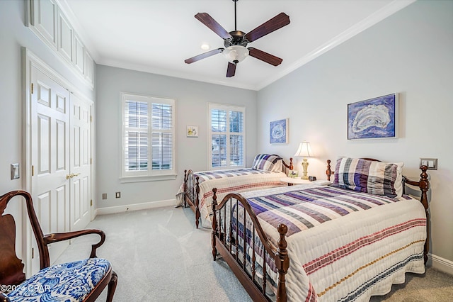 bedroom with crown molding, light carpet, ceiling fan, and a closet