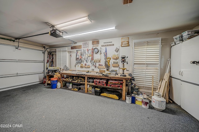 garage with a garage door opener and a workshop area