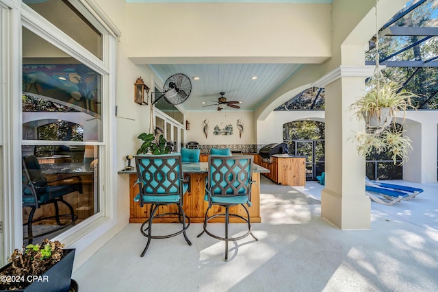 view of patio with grilling area, an outdoor bar, and ceiling fan