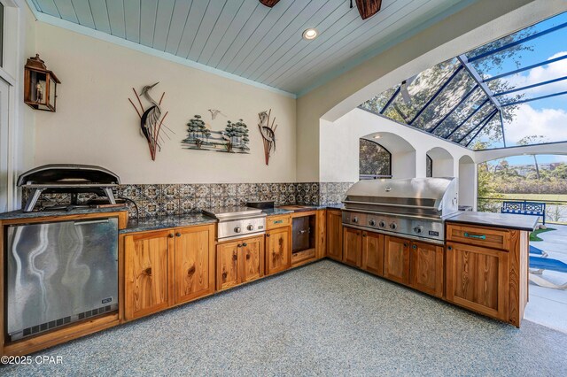 view of patio / terrace with exterior kitchen, a lanai, and grilling area