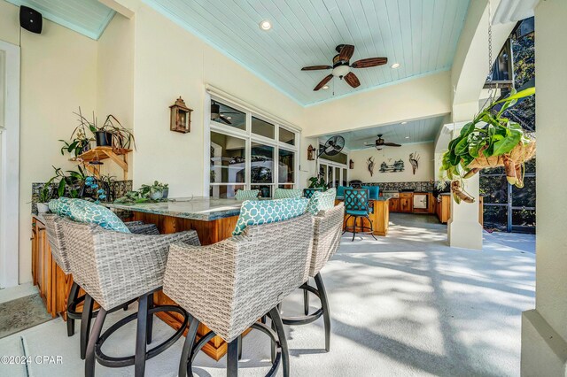 view of patio / terrace featuring exterior kitchen, a grill, and glass enclosure