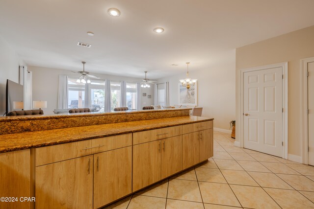 kitchen with light brown cabinets, ceiling fan with notable chandelier, decorative light fixtures, and light tile patterned floors