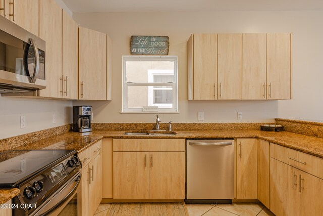 kitchen featuring stone counters, light brown cabinetry, and appliances with stainless steel finishes